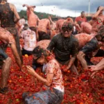 Thousands of revellers pelt each other with tomatoes at a…